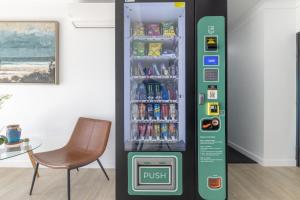 Una máquina expendedora de bebidas en una habitación con una silla. en Herston Place Motel, en Brisbane