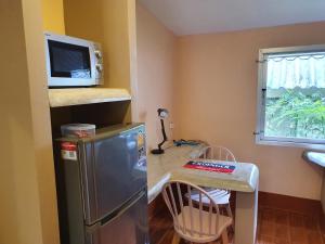 a kitchen with a refrigerator and a table with a microwave at Filou Villas in Ko Chang +101 photos