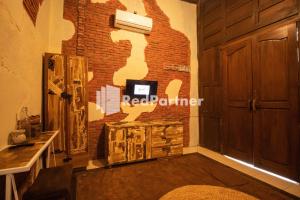 a room with a brick wall and a door at Djawata Resort & Gallery near Desa Wisata Kasongan Yogyakarta RedPartner in Yogyakarta