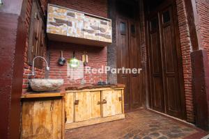 a kitchen with a sink and a brick wall at Djawata Resort & Gallery near Desa Wisata Kasongan Yogyakarta RedPartner in Yogyakarta