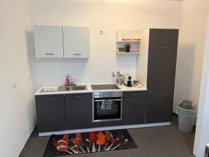 Una cocina con un fregadero y una estufa con comida sobre una alfombra. en Better Homes, en Oberhausen 4 fotos más