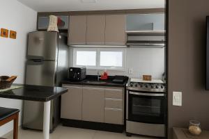 a kitchen with a refrigerator and a stove at Vista para as Montanhas in Guarapari