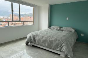a bedroom with a bed and a large window at Increíble Apartamento En Sogamoso in Sogamoso