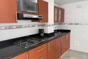 a kitchen with a stove top and a microwave at Increíble Apartamento En Sogamoso in Sogamoso