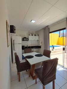 een keuken en eetkamer met een tafel en stoelen bij Casa & lazer - Com piscina aquecida e churrasqueira in Garanhuns