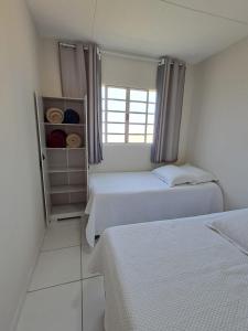 een slaapkamer met twee bedden en een raam bij Casa & lazer - Com piscina aquecida e churrasqueira in Garanhuns