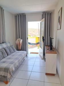 een slaapkamer met een bed en een televisie en een glazen schuifdeur bij Casa & lazer - Com piscina aquecida e churrasqueira in Garanhuns +72 foto's