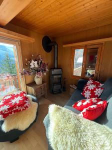 sala de estar con sofá azul y almohadas rojas en Chalet Montana mit Bergblick, en Brunig