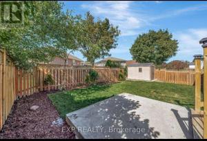 a backyard with a wooden fence and a yard at Luxurious home in Belleville in Bélanger