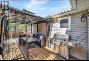 an outdoor patio with a grill and a table at Luxurious home in Belleville in Bélanger