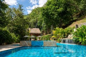 ein Pool in einem Resort mit Wasserfall in der Unterkunft Bio Rio Hotel in San Jerónimo