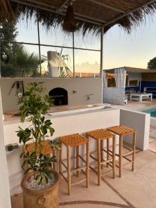 eine Terrasse mit Hockern und eine Bar mit Kamin in der Unterkunft Villa Aloe Vera Privée in Essaouira