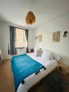ein Schlafzimmer mit einem großen Bett und einer blauen Decke in der Unterkunft Villa Aloe Vera Privée in Essaouira