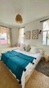 ein Schlafzimmer mit einem großen Bett und einer blauen Decke in der Unterkunft Villa Aloe Vera Privée in Essaouira