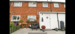 a white shed in front of a brick building at Stylish 3-Bed Maisonette - Sleeps 6 - Free Parking in Heswall