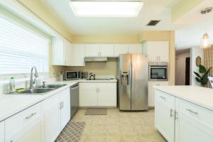 eine Küche mit weißen Schränken und einem Edelstahlkühlschrank in der Unterkunft Spacious 4 Bedroom Home near USSSA Complex in Rockledge