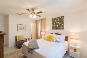 ein Schlafzimmer mit einem weißen Bett mit Deckenventilator in der Unterkunft Spacious 4 Bedroom Home near USSSA Complex in Rockledge