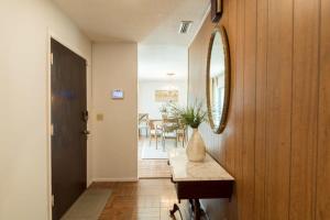 einen Flur mit einem Spiegel und einem Tisch in der Unterkunft Spacious 4 Bedroom Home near USSSA Complex in Rockledge + 27 Fotos
