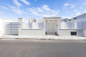 a white house with a door on a street at Pietrazzurra in Squinzano