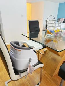 a white chair and a glass table with a basket on it at City Center Balcony by the Universities in Manchester