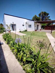 Casa con Jardín Las Marías 2 في ميرامار: بيت ابيض فيه نباتات في الساحه +37 صورة