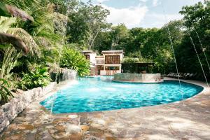 ein Swimmingpool mit Wasserfall vor einem Haus in der Unterkunft Bio Rio Hotel in San Jerónimo