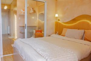 a bedroom with a large white bed and a mirror at Meraki Urban in Davao City +11 photos