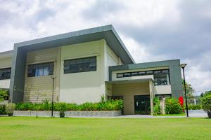 a large white building with a green at Meraki Urban in Davao City