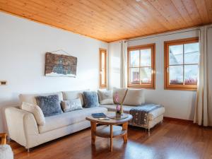 塔尔维西奥Chalet Alpino con Sauna a 4 min a piedi dalle piste da sci的客厅里有一张沙发和一张桌子。