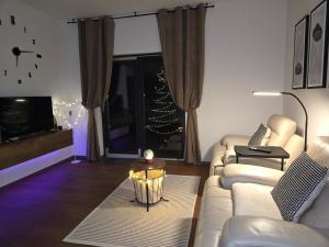 een woonkamer met een witte bank en een groot raam bij Simple&Cozy in Varaždin