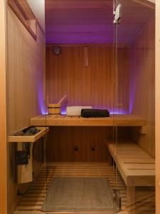 塔尔维西奥Chalet Alpino con Sauna a 4 min a piedi dalle piste da sci的一间室内紫色照明的桑拿浴室