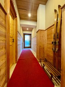 a hallway with a red carpet and wooden walls and a door at Case Vacanza Perron in Sauze dʼOulx