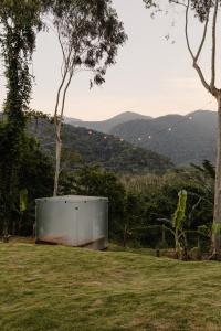 a metal box sitting on top of a grass field at Mōmento Itamambuca in Ubatuba