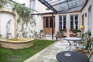 a patio with a fountain and tables and chairs at Maison la Louise in Ligny-en-Barrois
