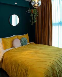 a bedroom with a yellow bed with a blue wall at Bloum at 22, City Views and Wonderland Vibes! in Hatillo