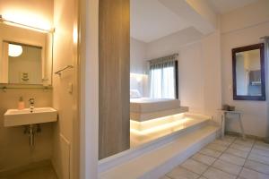 a bathroom with a sink and a bed and a mirror at Vista Petros in Apraos +84 photos