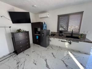 a kitchen with a counter and a sink and a refrigerator at Loft's PB in Mérida