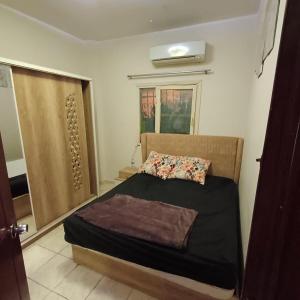 a small bedroom with a bed and a window at Cozy Mini Villa with a backyard in 6th Of October