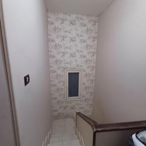 a hallway with a staircase with a window and wallpaper at Cozy Mini Villa with a backyard in 6th Of October +3 photos