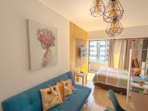 a living room with a blue couch and a bed at Departamento exclusivo a un paso de San Isidro in Lima +27 photos