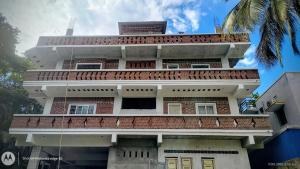 a tall building with balconies on top of it at Five Falls RAMANA VILLA in Kuttālam