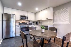 Una cocina con una mesa con sillas y un refrigerador. en Stay Longer, Save 10 percent, Relax in Comfort 15, en Houston 19 fotos más