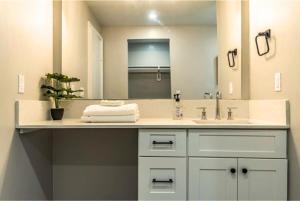 Un baño con lavabo y un espejo grande. en Stay Longer, Save 10 percent, Relax in Comfort 15, en Houston