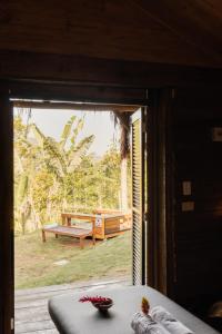 a room with a window with a view of a bench at Mōmento Itamambuca in Ubatuba