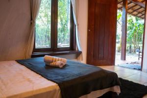 Ateliê Cultural Trancoso في ترانكوسو: غرفة نوم عليها سرير وفوط