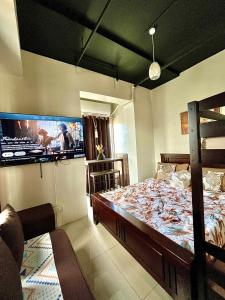 a bedroom with a large bed and a flat screen tv at Affordable staycation at Casa Andrea in Manila