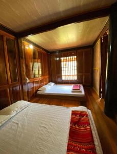 een slaapkamer met twee bedden en een raam erin bij ThongDong Homestay in Hữu Lũng