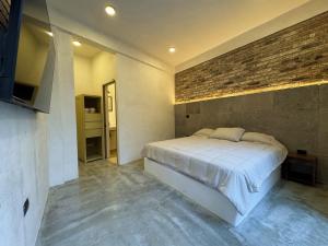 Villa Zamora 52 Coatepec Centro في كواتيبيك: غرفة نوم بها سرير وجدار من الطوب