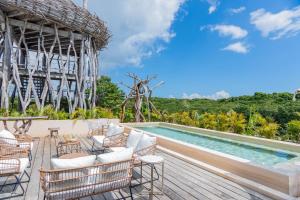 una piscina presso il resort con sedie e tavolo di Kuunaa Tulum I Beer Sanctuary & Spa a Tulum