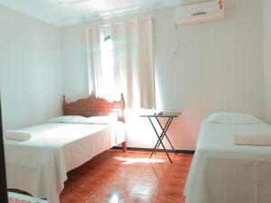 a room with two beds and a window at Hotel Minas Brasil in Salinas +8 photos